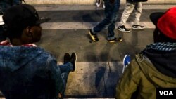 FILE - Groups from all over Africa chat, play football and more at the Milan Central Station, one of many hub points for throngs of migrants who have arrived in Italy, Oct. 12, 2016.