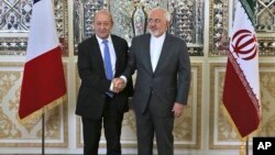 Iranian Foreign Minister Mohammad Javad Zarif, right, and his French counterpart Jean-Yves Le Drian, shake hands for journalists at the start of their meeting in Tehran, March 5, 2018. 