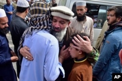 Relatives comfort one another during a funeral prayer for a train attack victim in Quetta, Pakistan's southwestern Balochistan province, March 13, 2025.