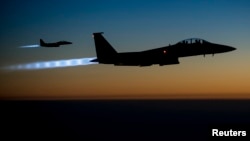 FILE - A pair of U.S. Air Force F-15E Strike Eagles fly over northern Iraq after conducting airstrikes in Syria, in this U.S. Air Force handout photo taken Sept. 23, 2014. These aircraft were part of a large coalition strike package that was the first to 