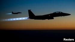 FILE - A pair of U.S. Air Force F-15E Strike Eagles fly over northern Iraq after conducting airstrikes in Syria, in this U.S. Air Force handout photo taken Sept. 23, 2014. 