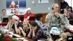 FILE - NORAD and U.S. Northern Command Chief of Staff Maj. Gen. Charles Luckey joins other volunteers taking phone calls from children around the world asking where Santa is, at Peterson Air Force Base, Colo., Dec. 24, 2014.