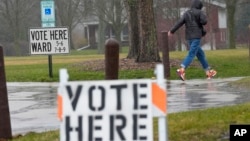 FILE - A voter braves a cold rain running to cast a ballot during the spring election, April 2, 2024, in Fox Point, Wisconsin.