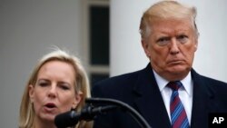 Tổng thống Donald Trump nghe Bộ trưởng An ninh Nội địa Kirstjen Nielsen phát biểu tại Vườn Hồng Tòa Bạc ốc ngày 4/1/20119 sau khi gặp các nhà lãnh đạo Quốc hội về an ninh biên giới. 