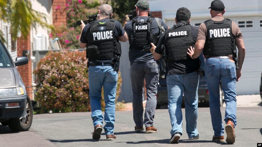 Petugas kepolisian San Diego mendekati rumah yang diyakini merupakan tempat tinggal John T. Earnest (19), yang diduga pelaku penembakan di sinagoga Poway, San Diego, California, Sabtu, 27 April 2019. (John Gibbins / The San Diego Union-Tribune via AP)