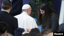 Pope Francis is welcomed by Nour Essa, a Syrian refugee, as he arrives to attend a meeting at Roma Tre University in Rome, Italy, Feb. 17, 2017.