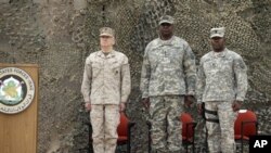 Gen. Lloyd Austin, le commandant américain numéro un en Irak, centre, débout au cours des cérémonis de la fin de la mission américaines à Bagdad, Irak, juedi 15 décembre 2011. 