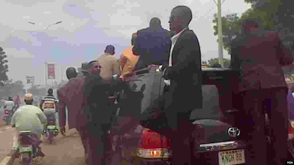 Manjo Hamza Al-Mustapha waves to people escortin ghim as he arrives in Kano.