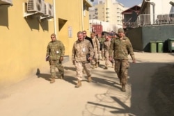 امریکی کمانڈر جنرل مک کینزی (درمیان میں) کابل کے دورے کے موقع پر مقامی کمانڈروں کے ہمراہ۔ 31 جنوری 2020