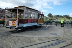 A cable car operator looks out toward the Golden Gate Bridge while standing at the near-empty Hyde Street turnaround in San Francisco, March 16, 2020.
