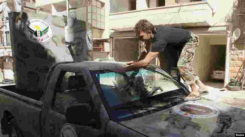 A member of &quot;Free Men of Syria&quot; brigade, operating under the Free Syrian Army, washes a vehicle in Aleppo&#39;s Bustan al-Qasr, Sept. 9, 2013. 