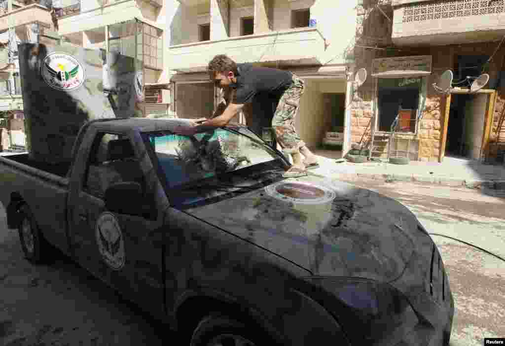 A member of &quot;Free Men of Syria&quot; brigade, operating under the Free Syrian Army, washes a vehicle in Aleppo&#39;s Bustan al-Qasr, Sept. 9, 2013. 