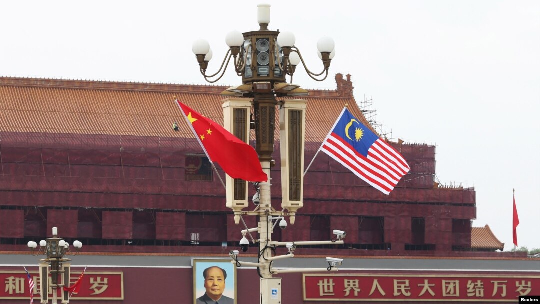 Bendera Malaysia berkibar di sebelah bendera China (kiri) di Lapangan Tiananmen, saat kunjungan Perdana Menteri Mahathir Mohammad di Beijing, China, 19 Agustus 2018. (Foto: Stringer/Reuters)
