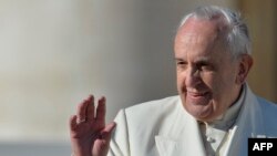 Pope Francis waves to the crowd during his general audience at St Peter's square at the Vatican on Dec. 10, 2014.