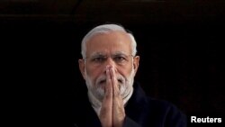 FILE - India's Prime Minister Narendra Modi holds up his hands in a "namaste," a traditional Indian greeting, as he arrives for an official visit to Britain, in London, Nov. 12, 2015.