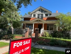 FILE - A "FOR SALE" sign stands outside a house in Denver, Colorado, Aug. 27, 2024.