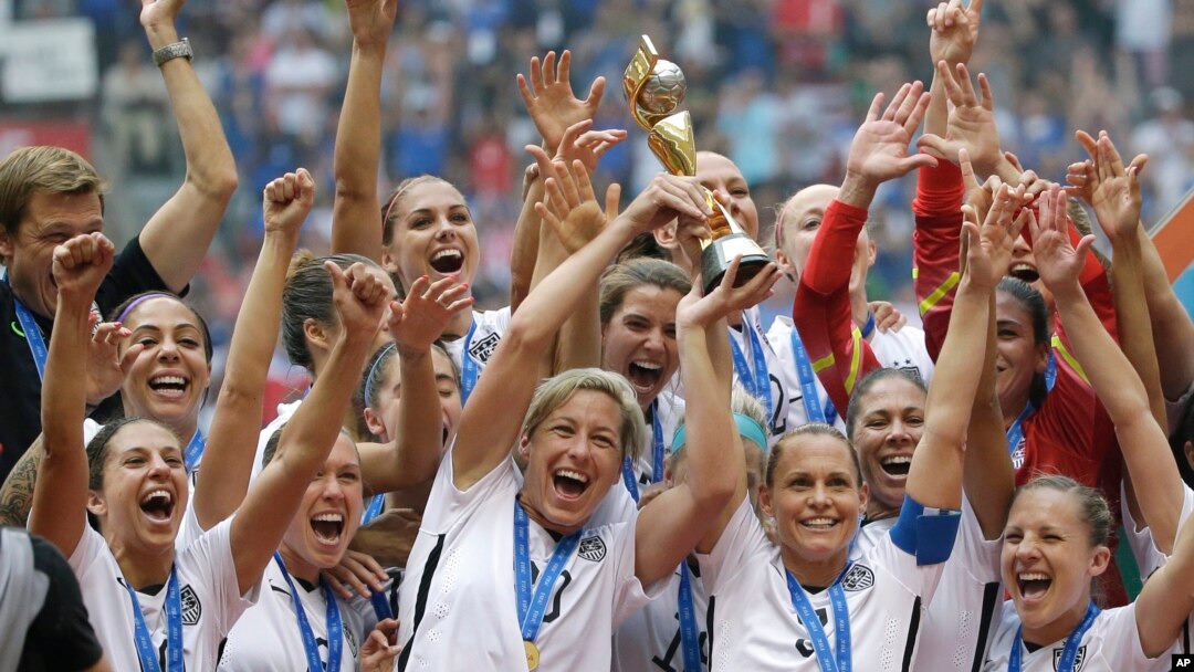 Tim nasional putri AS merayakan kemenangan dengan trofi yang mereka raih setelah mengalahkan Jepang 5-2 dalam kejuaraan sepak bola Piala Dunia Putri FIFA di Vancouver, Kanada (5/7). (AP/Elaine Thompson)