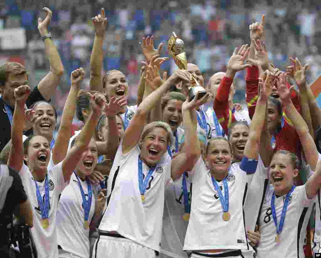 A equipa nacional feminina dos EUA celebra a sua vitória com o troféu após ter ganho o Japão 5-2 no campeonato do Mundial Feminino da FIFA em Vancouver, Canadá, no Domingo, 5 de Julho, 2015.