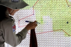 Captain Nguyen Thi Thuy of all-female landmines clearance team marks detected zones on a map of Hai Lang district, near a former U.S military base used during Vietnam War, in Quang Tri province, Vietnam, March 4, 2020.