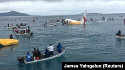 People are evacuated from an Air Niugini plane that crashed in the waters in Weno, Chuuk, Micronesia, Sept. 28, 2018 in this picture obtained from social media.