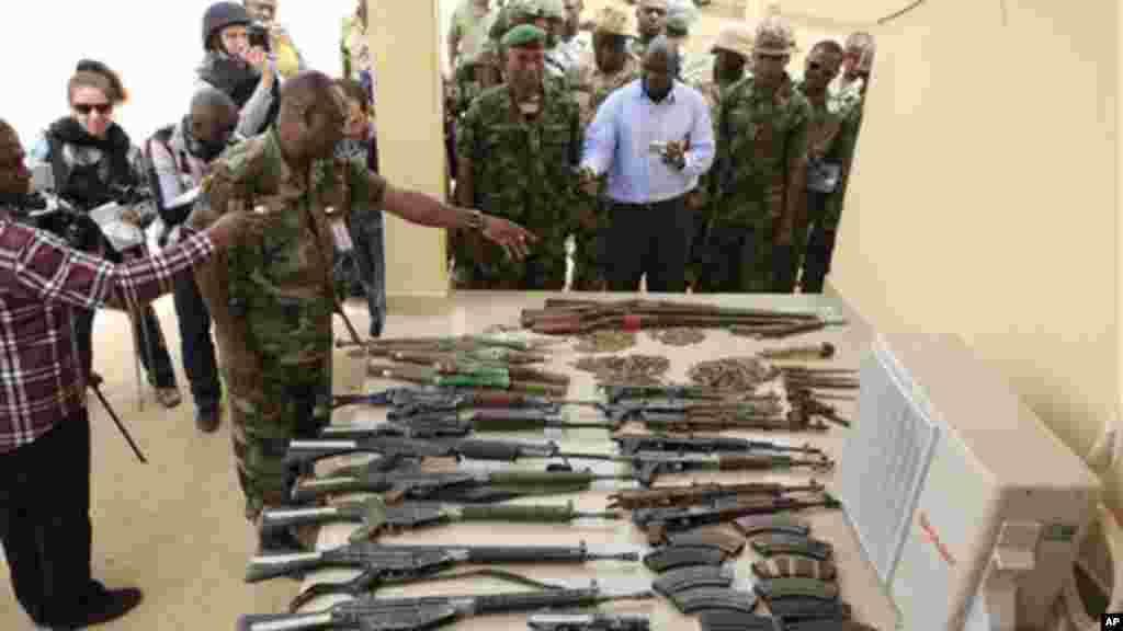 Journalists look at arms and ammunition which military commanders say they previously seized from Islamic fighters in Maiduguri, Nigeria.