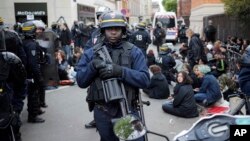 FILE - Riot police detain protesters after clashes broke out with activists on the sidelines of the traditional May Day rally in the center of Paris, France, May 1, 2018. 