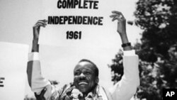 Rais wa kwanza wa Tanzania Julius Nyerere akibeba bango kutangaza Uhuru wa Tanganyika.