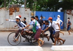 People transport a person who was shot during a security force crackdown on anti-coup protesters in Thingangyun, Yangon, Myanmar, March 14, 2021.