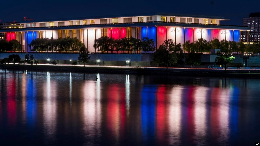 Luces rojas, blancas y azules que marcan el centenario del nacimiento del presidente John F. Kennedy, en el Kennedy Center se reflejan en las aguas del río Potomac, en Washington, el 26 de mayo de 2017.