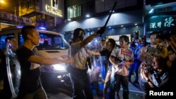 Seorang polisi anti hurt-hara mengacungkan pentungannya saat berhadapan dengan para pengunjuk rasa "Occupy Central" di distrik Mongkok, Hong Kong (4/10).