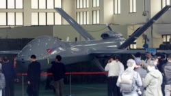 Para pengunjung memperhatikan sebuah drone di Institut Nasional Sains dan Teknologi Chung-San di Taichung City, Taiwan, 14 Maret 2023. (Foto: Chiang Ying-ying/AP Photo)