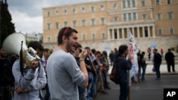 FILE - Protesters chant anti-austerity slogans in front of the Greek Parliament in central Athens, May 6, 2016. 