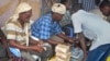 FILE - A customer of Dahabshiil, a Somali remittance company, exchanges U.S. dollars for Somali shillings outside the company's headquarters in Mogadishu, Somalia.