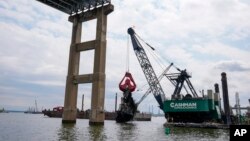 ARCHIVO - Trabajadores retiran los restos del puente Francis Scott Key derrumbado, el jueves 25 de abril de 2024, en Baltimore