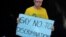 FILE -  An albino holds a placard during an Albinism awareness campaign in Harare, Zimbabwe, June 18, 2016. 
