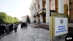 FILE - People walk outside the Palace of the Republic in Chisinau during an opening session of the Moldovan Parliament. 