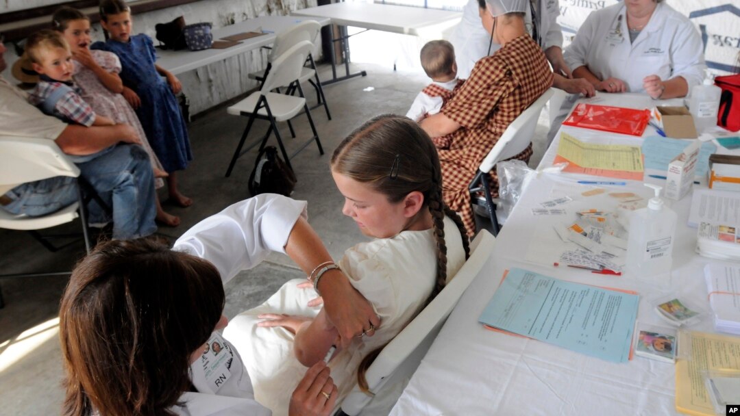 Seorang anak divaksinasi MMR di sebuah klinik Shiloh, Ohio, sementara anak-anak lain menunggu giliran. (Foto: Dok)