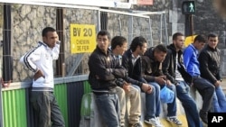 Migrants of North African origin who hold temporary travel documents issued by Italy gather near the ring road of Paris April 29, 2011.