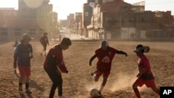 Niños juegan al fútbol cerca del estadio municipal Villa Ingenio en El Alto, Bolivia, el jueves 29 de agosto de 2024.