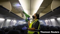 کارمند شرکت هواپیمایی «یونایتد» در حال ضدعفونی کردن داخل هواپیما (آرشیو)