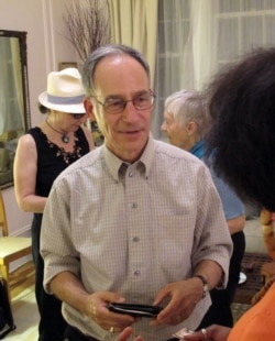 FILE - Robb Kushner, center, talks with Alicia Evans during a Death Cafe discussion in a New York City apartment, Oct. 8, 2013. Death Cafes, where people talk freely about death-related issues, are spreading through the U.S. and the world.