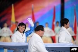 A former athlete waves while carrying the Olympic Council of Asia flag during the opening ceremony of the Asian Games in Hangzhou, China, on Sept. 23, 2023.