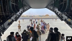In this photo provided by the Spanish Defence Ministry, people board a Spanish air force A400 plane as part of an evacuation plan at Kabul airport in Afghanistan, Aug.18, 2021. 