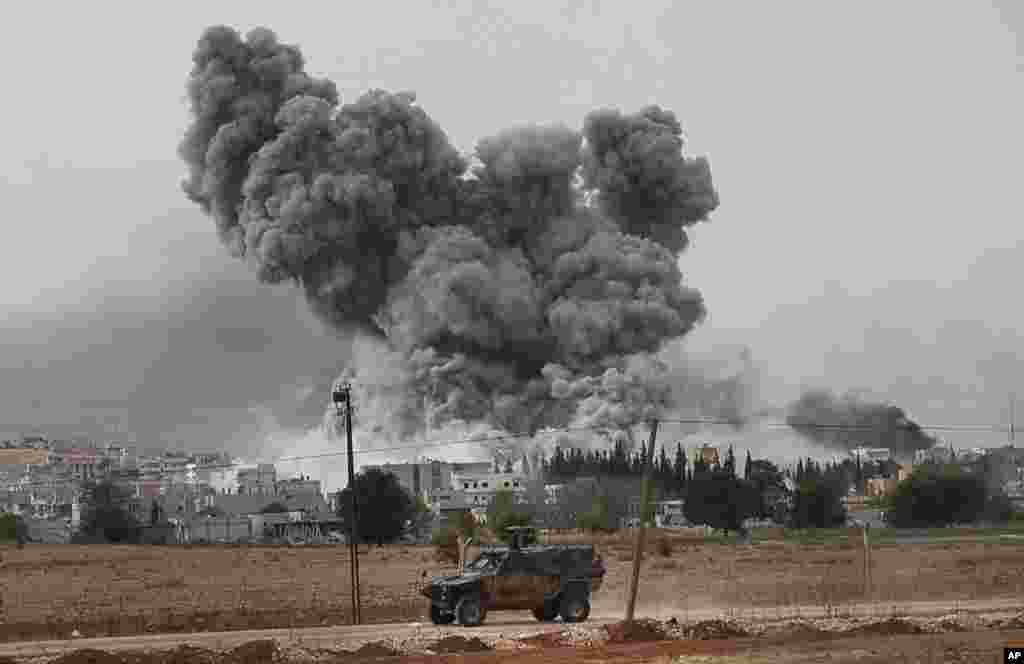 Epaisse fumée et débris s&#39;élèvent après une frappe de la coalition menée oar les Etats-Unis à Kobani, en Syrie, dimanche le 12 ocotbre 2014. (AP Photo/Lefteris Pitarakis) 