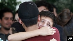 Youths comfort each other in Ciudad Juarez, Mexico, at the funeral of elementary school principal Elsa Mendoza, one of the 22 people killed in a shooting at a Walmart in El Paso, Texas, Aug. 8, 2019