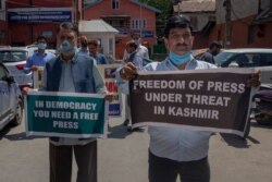 FILE - Kashmiri journalists hold placards during a protest against a media policy that was announced last month in Srinagar, Indian controlled Kashmir, July 6, 2020.