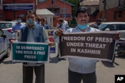 FILE - Kashmiri journalists hold placards during a protest against a media policy that was announced last month in Srinagar, Indian controlled Kashmir, July 6, 2020.