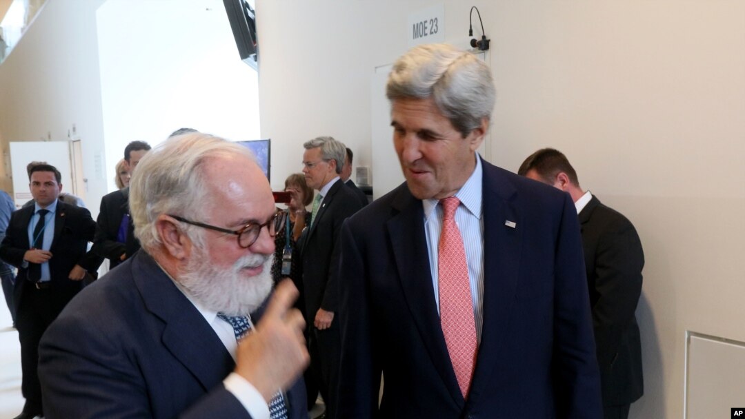 Menteri Luar Negeri John Kerry (kanan) berbincang dengan Komisioner Iklim Uni Eropa Miguel Arias Canete di Wina, Austria (22/7). (AP/Ronald Zak)