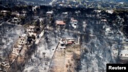 Foto udara wilayah permukiman yang dilanda kebakaran di kota Mati, dekat Athena, Yunani (25/7). Kebakaran hutan di Yunani telah menewaskan lebih dari 80 orang.