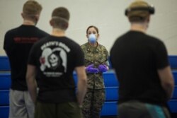 FILE - Lt. Cmdr. Jennifer Knapp with 3rd Medical Battalion, 3rd Marine Logistics Group, briefs U.S. Navy sailors assigned to the aircraft carrier USS Theodore Roosevelt on coronavirus disease quarantine procedures at Naval Base Guam, April 8, 2020.
